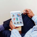 Graphics - Man Wearing White and Blue Pinstriped Dress Shirt Holding White Ipad