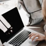 Backup - Close-up Photography of Woman Sitting Beside Table While Using Macbook