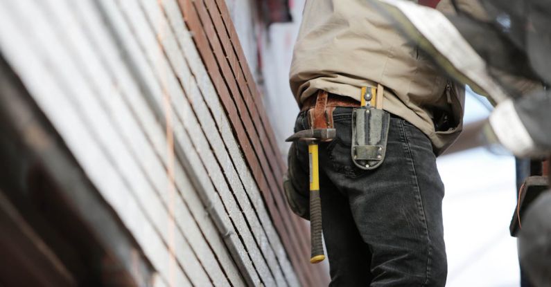 Builder - Man Wearing Black Denim Pants With Carrying Hammer on Holster