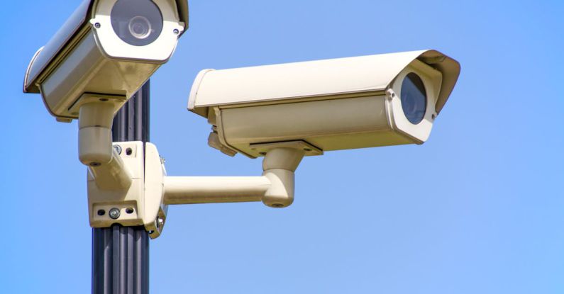 Security - White 2 Cctv Camera Mounted on Black Post Under Clear Blue Sky